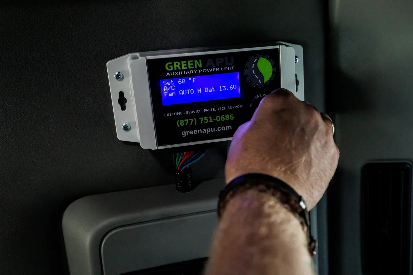 A driver using the Green APU controller, which displays the 24/7 support number