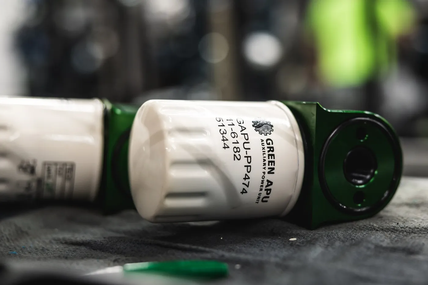 A Green APU oil filter — a standard automotive part available at any parts store
