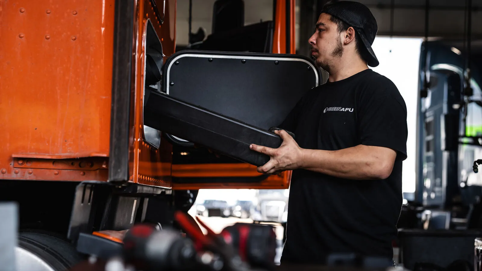 A Green APU technician working on a truck